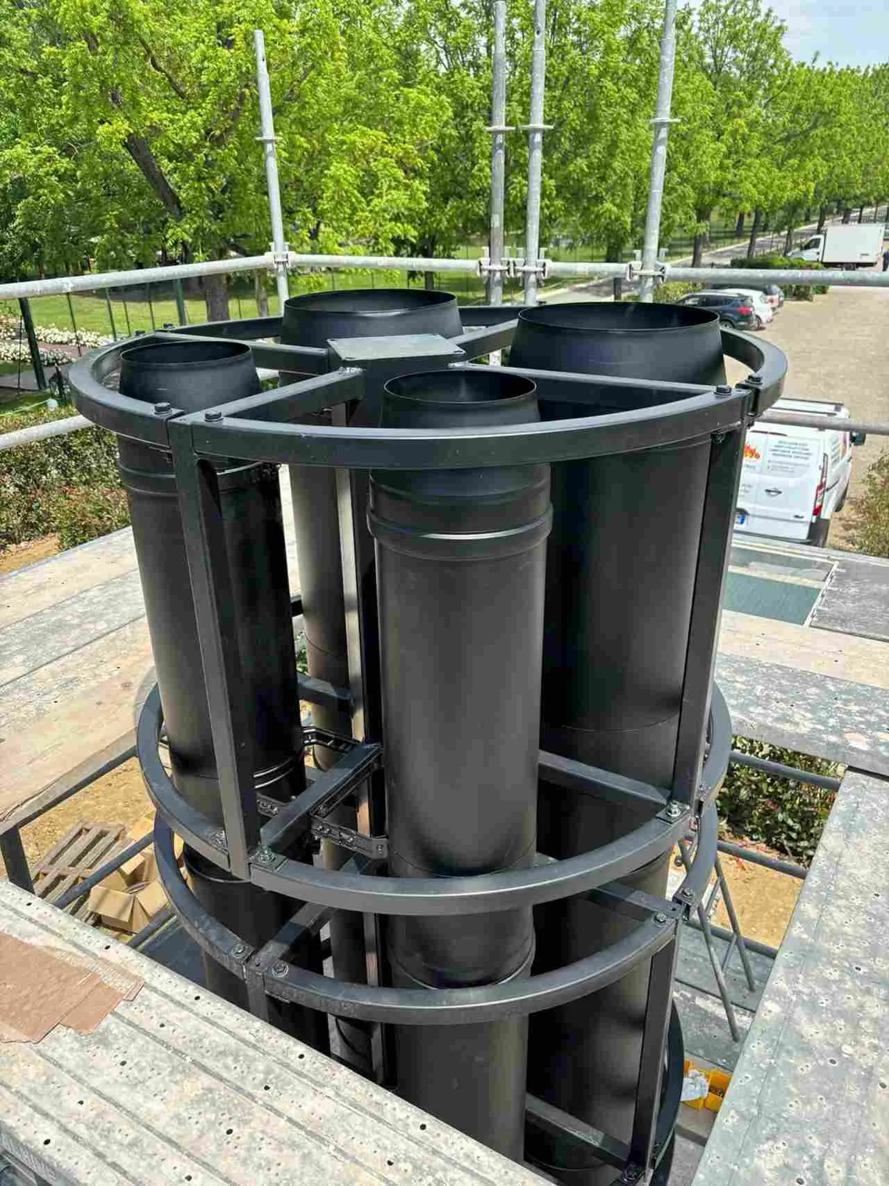 Gruppo di canne fumarie a doppia parete in acciaio verniciato nero RAL, pronte per l'installazione su un impianto di riscaldamento complesso.